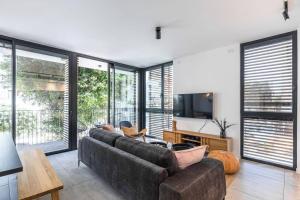 a living room with a couch and a tv at Gordon Beach by Five Stay in Tel Aviv