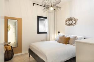a bedroom with a bed with a mirror and a chandelier at Gordon Beach by Five Stay in Tel Aviv