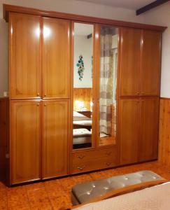 a large wooden cabinet in a bedroom at Appartamento Diana Cervia in Cervia