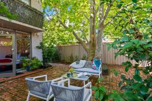 a patio with chairs and a table and a tree at Romantic Retreat with Garden in Melbourne