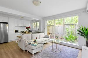 a living room with a couch and a kitchen at Romantic Retreat with Garden in Melbourne