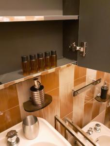 a bathroom with a sink and a shelf with jars at Appartamento Diana Cervia in Cervia