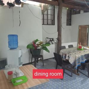 een eetkamer met een tafel en stoelen en een eetkamer bij Fely's Homestay in Batuan