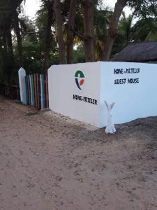 a wall with a sign that reads name fisher at KONE-METTLER GUEST HOUSE in Abémé