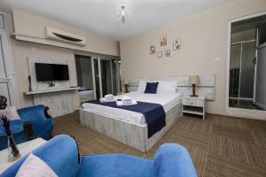 una camera d'albergo con un letto e una tv di MELODİ BUTİK OTEL a Edremit