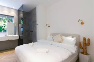 1 dormitorio blanco con 1 cama grande y lavamanos en Green Harmony by Five Stay, en Tel Aviv