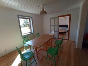 a room with a wooden table and green chairs at original Schwedenhaus in Borghamn