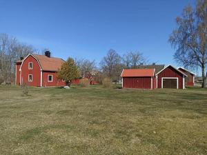 a red barn and a red house in a field at original Schwedenhaus in Borghamn