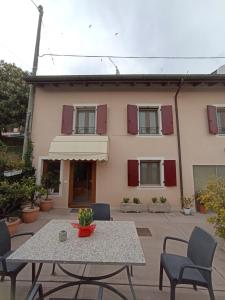 a table and chairs in front of a house at vololiberoapartments in Borso del Grappa