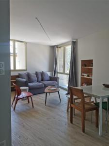 salon z niebieską kanapą i stołem w obiekcie Villard de Lans, coeur de village.Bel appartement w mieście Villard-de-Lans