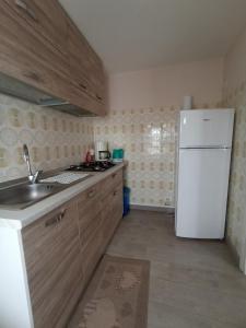 uma cozinha com um lavatório e um frigorífico branco em vololiberoapartments em Borso del Grappa