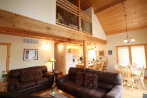 sala de estar con 2 sofás de cuero y cocina en River's Edge Resort en Winthrop