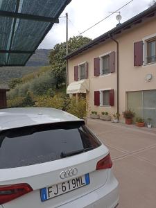 a white car parked in front of a building at vololiberoapartments in Borso del Grappa