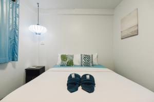 a bedroom with a bed with two pairs of slippers at Your Home AYUTTHAYA ยัวร์โฮม in Phra Nakhon Si Ayutthaya