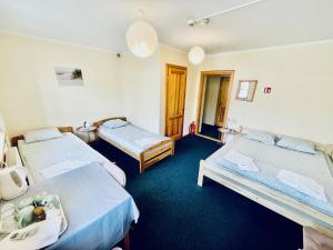 a hotel room with two beds and blue carpet at Express Guest House in Klaipėda