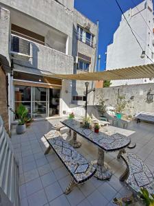 patio ze stołem i ławkami oraz budynek w obiekcie Palermo Soho Hostel w BuenosAires
