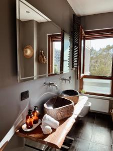 łazienka z dużą umywalką i lustrem w obiekcie KeRo Luxury Rooms w Cagliari