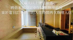 a bathroom with a bath tub in a room at Janeeyre Motel in Taichung