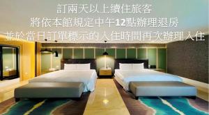 2 camas en una habitación de hotel con un cartel encima en Janeeyre Motel, en Taichung