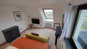 a living room with a yellow couch and a television at Achalochan House in Ose