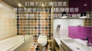 a bathroom with a toilet and a sink at Janeeyre Motel in Taichung