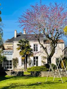 a house with a tree and a swing at Maison de charme de 280m2 avec piscine chauffée … in Luçon