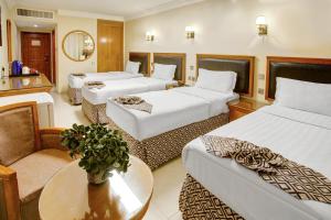 pokój hotelowy z 3 łóżkami i stołem w obiekcie Dweik Hotel LUXURY 3 w Akabie