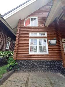 uma casa de madeira com duas janelas em Villa Puncak Little Venice - Kota Bunga em Cikujang