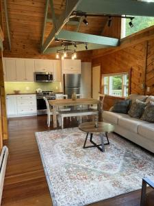 uma cozinha e sala de estar com um sofá e uma mesa em Chalet with a Private Beach in Acadia National Park em Bar Harbor