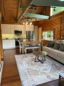 a kitchen and living room with a couch and a table at Chalet with a Private Beach in Acadia National Park in Bar Harbor