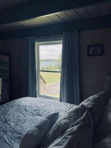 a bedroom with a bed and a large window at Chalet with a Private Beach in Acadia National Park in Bar Harbor