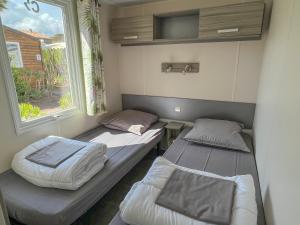 two beds in a room with a window at Sas Robrecht in Saint-Tropez