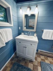 a blue bathroom with a sink and a mirror at Chalet with a Private Beach in Acadia National Park in Bar Harbor