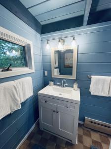 a blue bathroom with a sink and a mirror at Chalet with a Private Beach in Acadia National Park in Bar Harbor