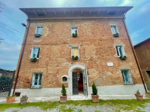 un antiguo edificio de ladrillo con una puerta y plantas en Magical Villa Gioiella 6 Bedroom Holiday Home on the Umbria Tuscany Border, en Gioiella