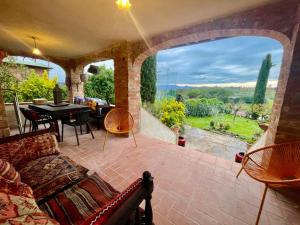 ein Wohnzimmer mit Couch und großem Fenster in der Unterkunft Magical Villa di Gioia Breathtaking views, large private garden and olive grove - in a cool village on the Umbria Tuscany Border in Gioiella