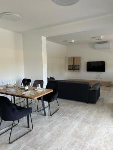 a dining room with a table and chairs and a couch at Modern Home Ula in Brtonigla