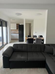 a living room with a black couch and a kitchen at Modern Home Ula in Brtonigla