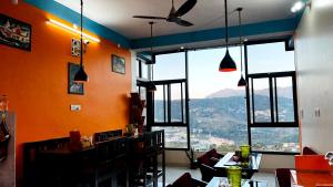 a restaurant with tables and chairs and a large window at MangalMurti Himalyan Hotel in Almora