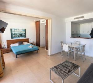 a bedroom with a bed and a table in a room at Amazing seafront apt in playa den bossa in Playa d'en Bossa