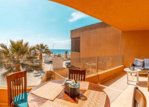balcón con mesa y vistas al océano en Amazing seafront apt in playa den bossa en Playa d'en Bossa