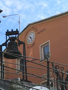 a clock on the side of a building with a bell at Golfo Paradiso Campane di Uscio piccola bomboniera pochi chilometri Camogli Portofino Santamargherita in Uscio