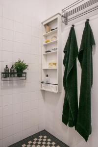 a bathroom with green towels hanging on a wall at Modernist Suite in the Old Town in Warsaw