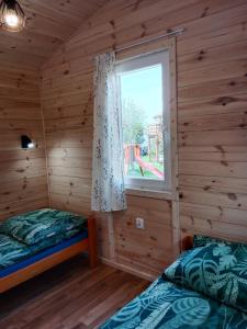 a bedroom with two beds and a window at Owocowe Wakacje - Domek nad jeziorem in Mikołajki