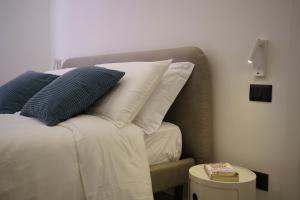 een slaapkamer met een bed met kussens en een bijzettafel bij Casa Chicotta in Palermo