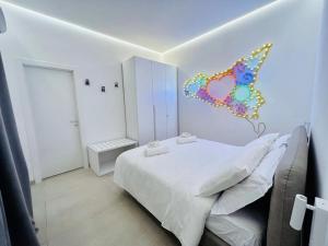 een witte slaapkamer met een bed en een spiegel bij Casa Chicotta in Palermo