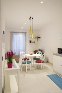 een witte woonkamer met een witte tafel en stoelen bij Casa Chicotta in Palermo