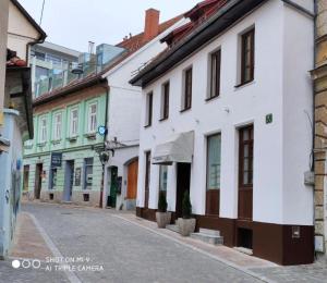 une rue vide dans une ville avec des bâtiments blancs dans l'établissement Aparthotel Cross Street 4, à Ljubljana