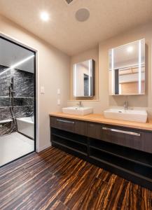 a bathroom with two sinks and a shower at Hotel Legit in Hiroshima