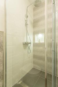 a shower with a glass door in a bathroom at Stipe in Obuljeno